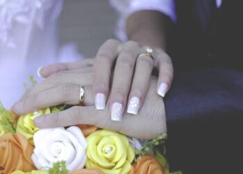 Manos con alianzas de matrimonio