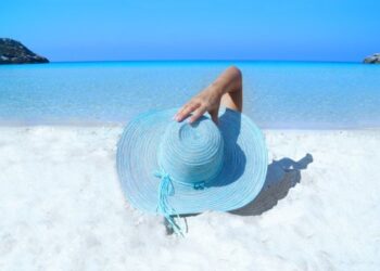 Chica con sombrero azul en la playa