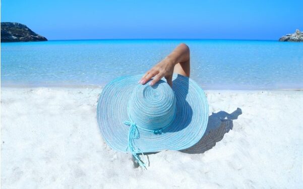 Chica con sombrero azul en la playa