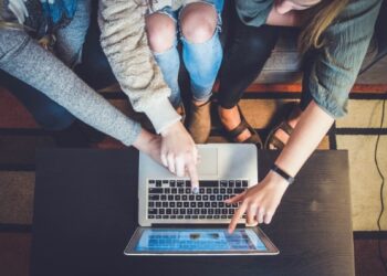 Chicas señalando portatil