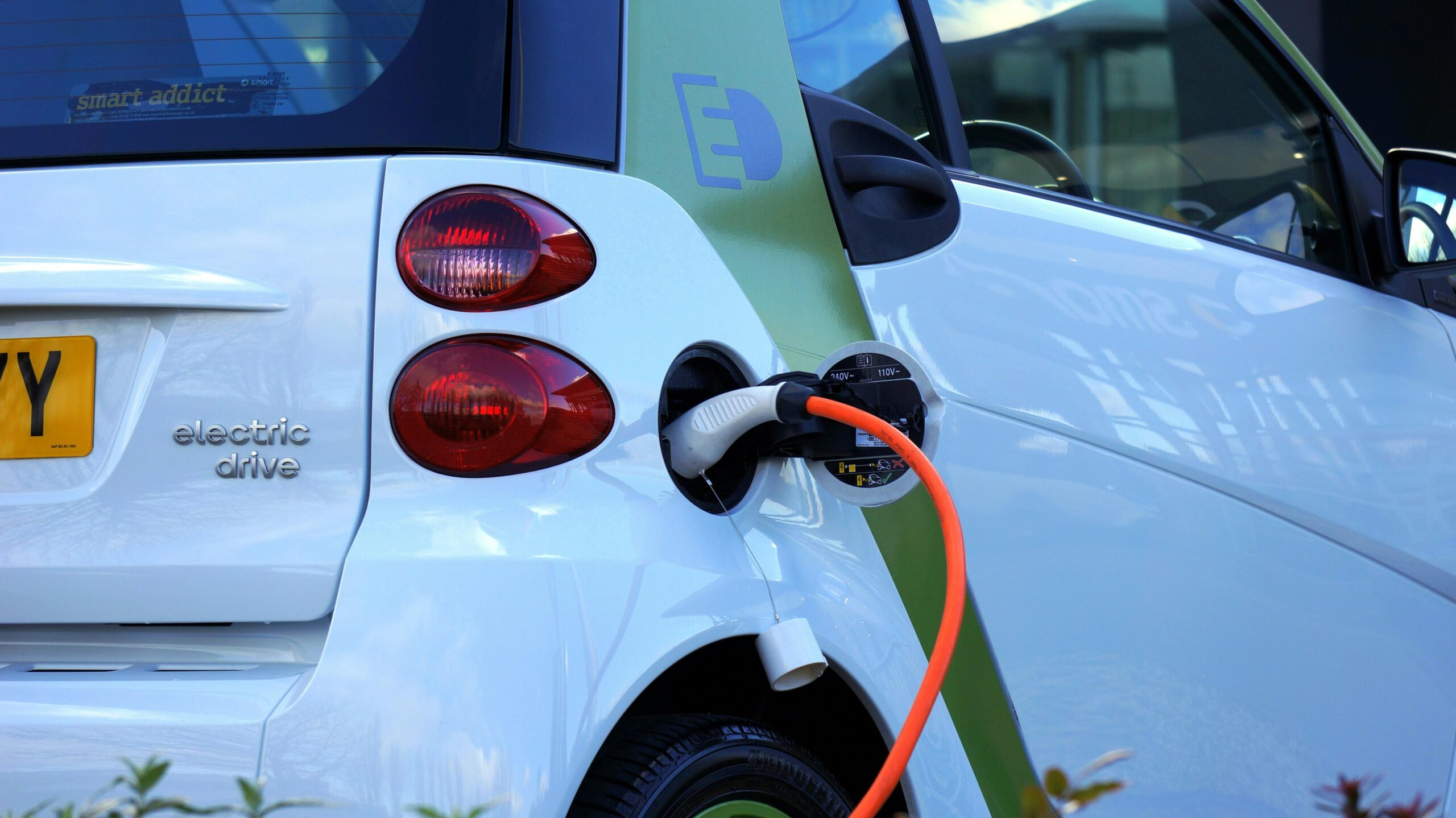 Coche eléctrico conectado a punto de carga recargando batería motor eléctrico