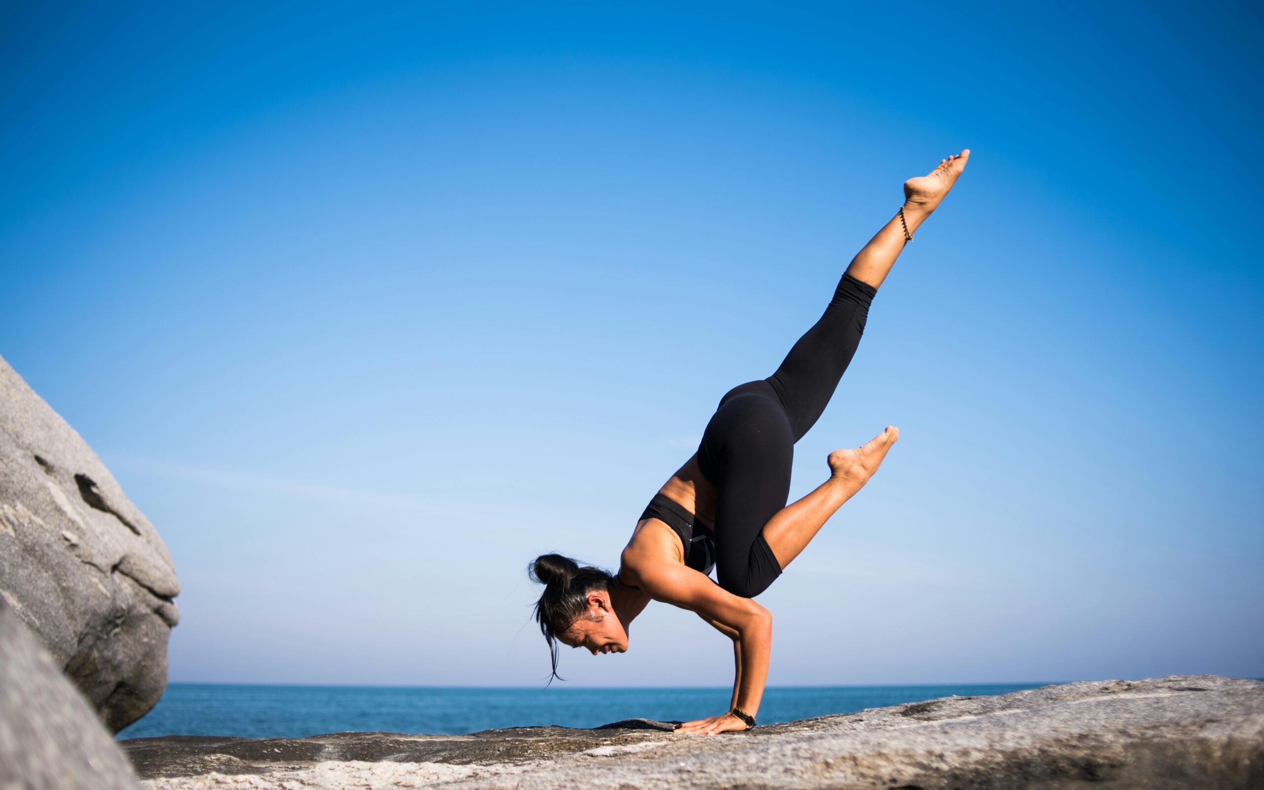 Mujer practicando yoga exterior amanecer bienestar salud equilibrio cuerpo mente posturas